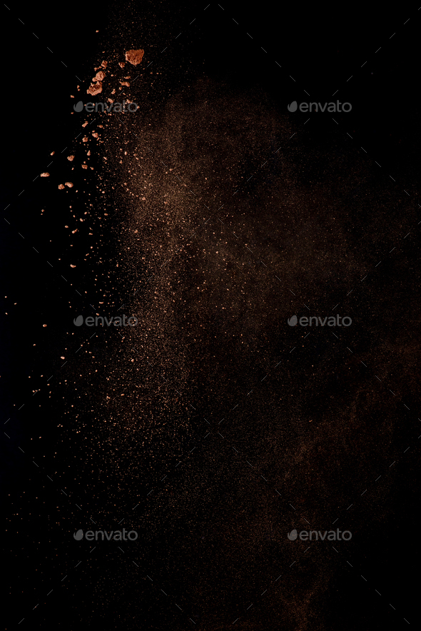Cocoa powder explosion in motion. Chocolate dust on a black background. Action food photography